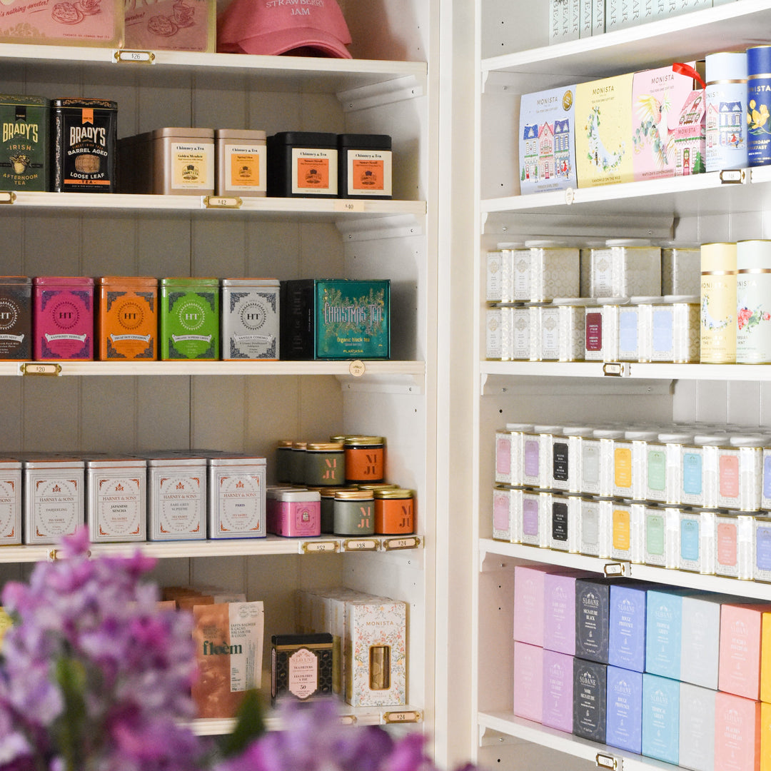 Shelves filled with various tea boxes and containers in a store setting.