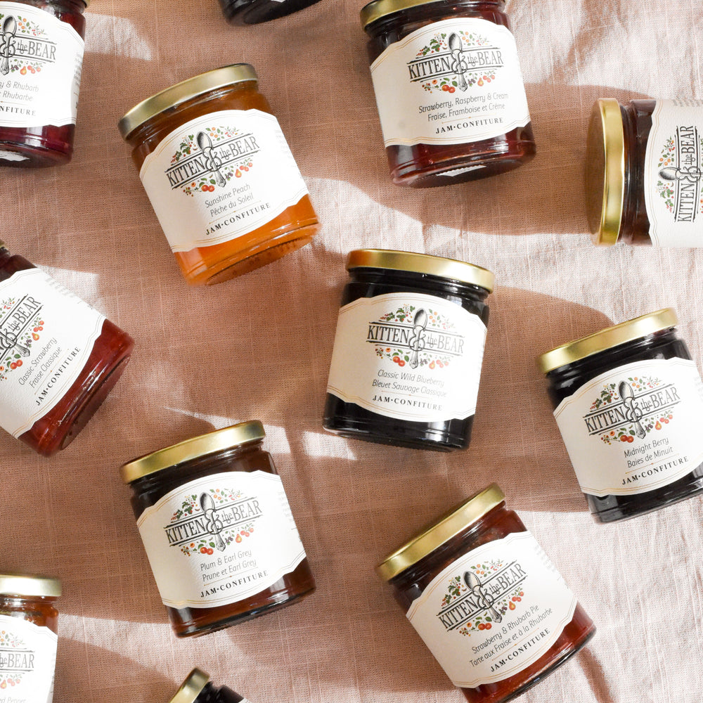 Jars of jam with labels on a textured surface